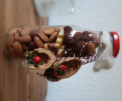 Flasche mit Anhängern aus Walnusschalen, gefüllt 