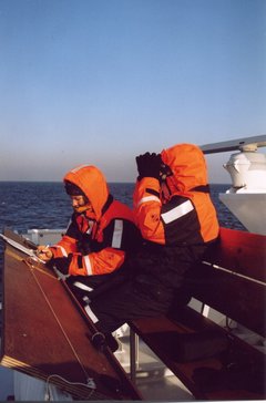 Zwei Forscher in Winteranzügen auf Schiff.