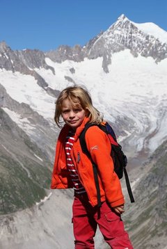 Ein Kind mit Rucksack im Hochgebirge