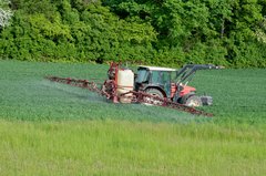 Traktor bringt Pestizide oder Dünger auf.